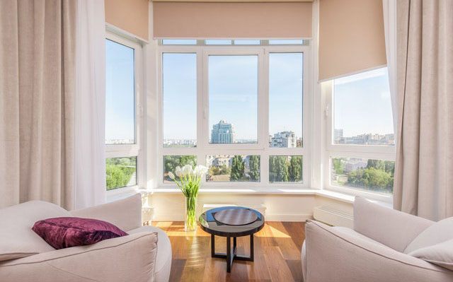 Sitting area with white chairs and large windows